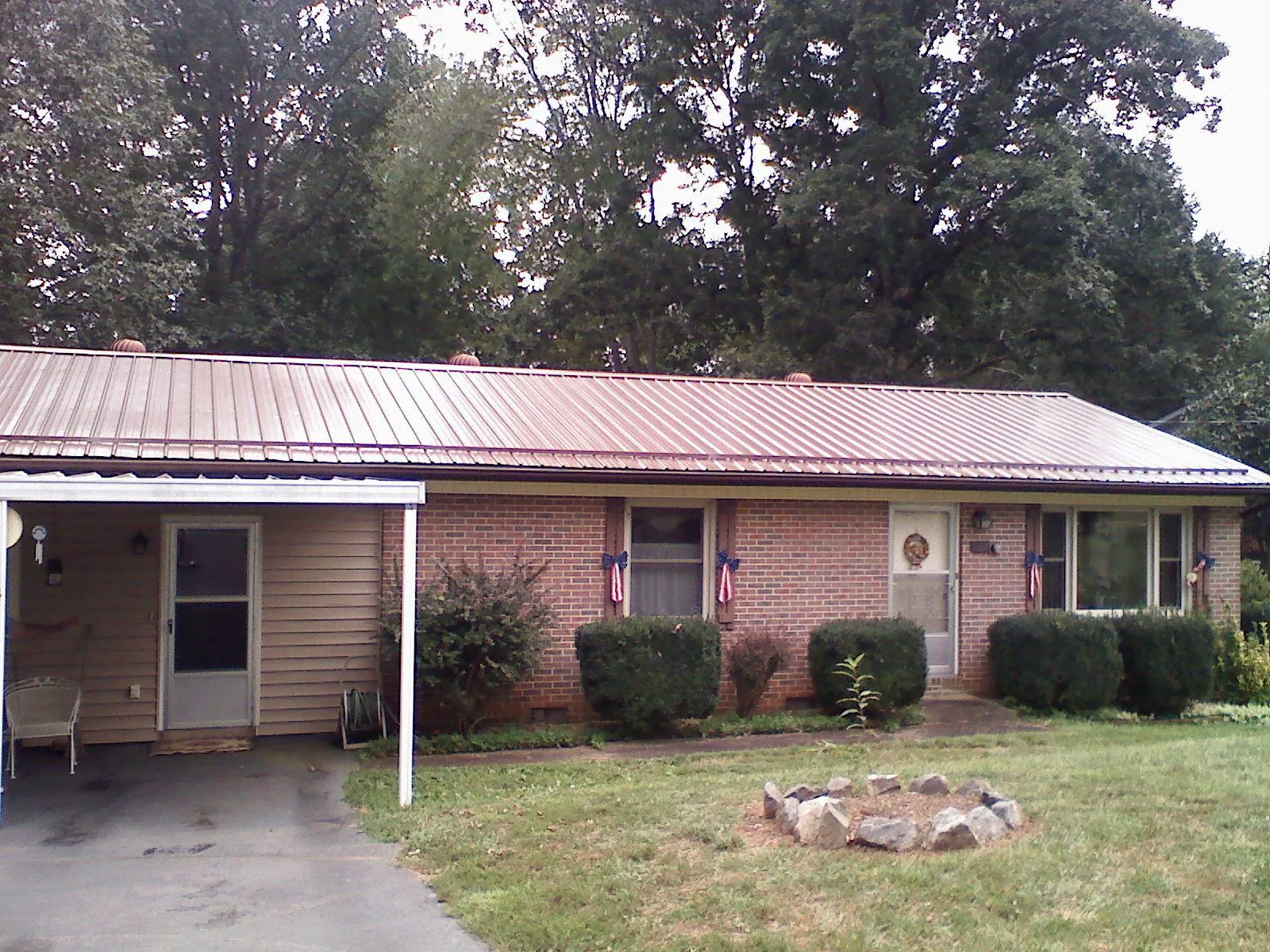 Bronze metal roof and carport on a brick ranch home — Roof Repair work by our crew in Ridge Spring